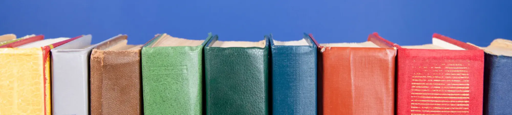 Row of different colored books on a dark blue background