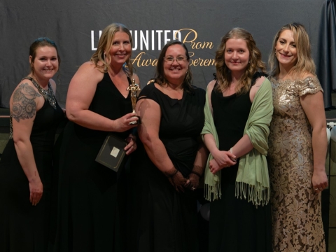 smiling women holding award