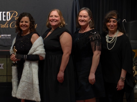 four smiling women holding award