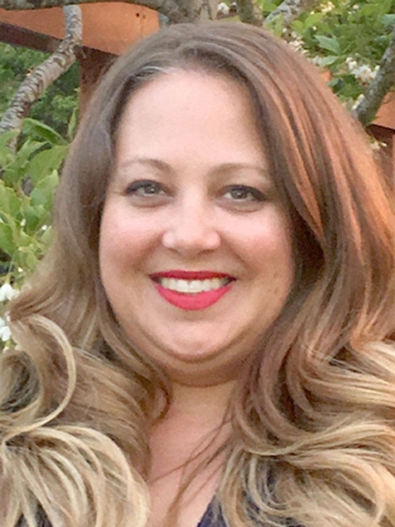 headshot of woman with curly blonde hair and red lipstick