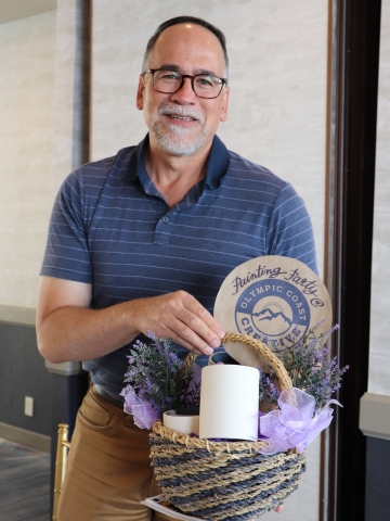 Man holding basket of white mugs