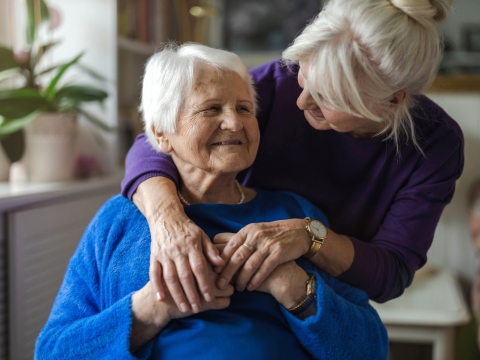 Two elderly women embracing