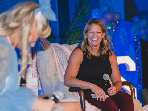 woman smiling on stage during interview