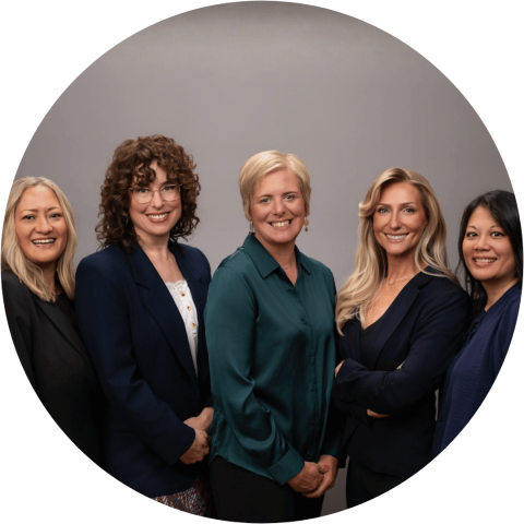 5 smiling women wearing business attire