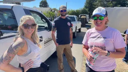 Three people smiling on a worksite